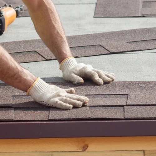 A Roofer Installs Shingles.
